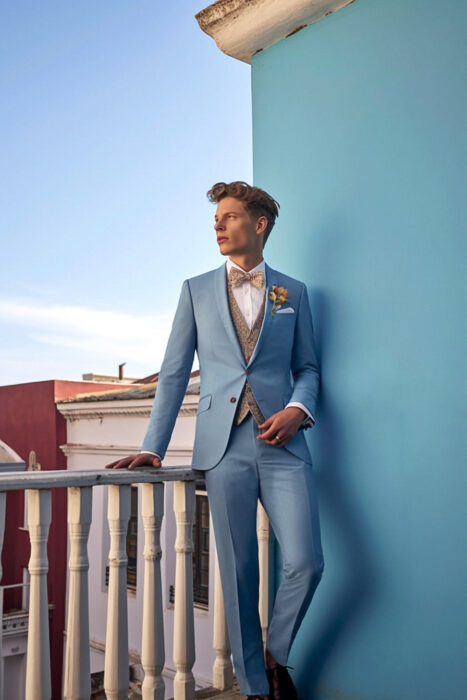 Photo d'un homme qui rigole et qui porte un costume bleu ciel avec un gilet beige fait par Chris Von Martial