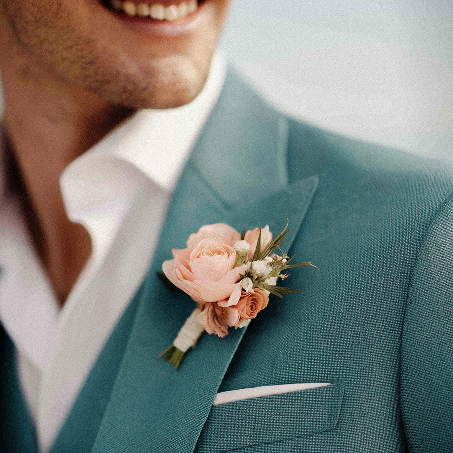 Gros plan sur costume bleu canard avec boutonnière Chris von Martial.